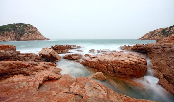 rocky sea coast and blurred water in shek o,hong kong 