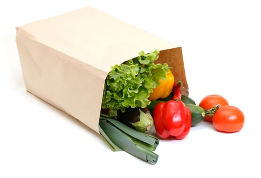 grocery bag full of vegetables isolated on white background