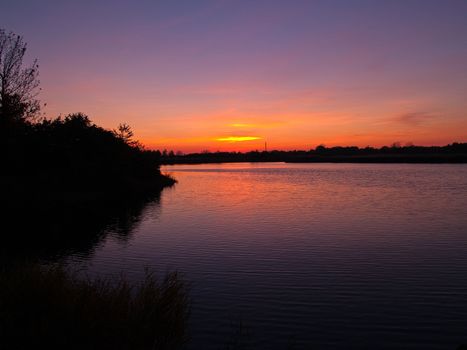 Beautiful dramatic sunset over a small countryside rural lake