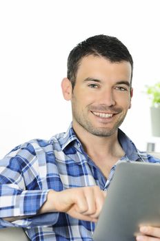 attractive relaxed and positive man is surfing on his tablet