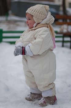 Little girl plays with snowball