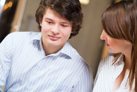 Attractive young man and woman sitting on the floor talking