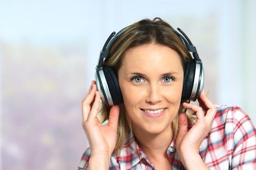 blond woman relaxing at home, listening music