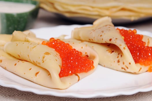 two pancake with red caviar on plate