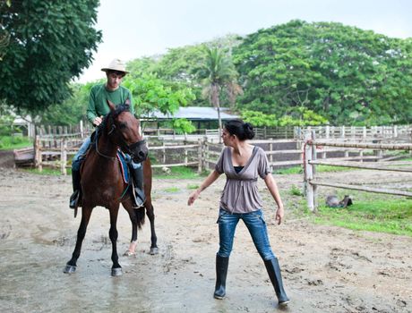 Couple of guys riding in the rain on a farm in Ecuador