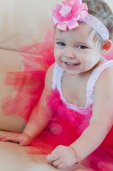 Little smiling girl in the pink dress