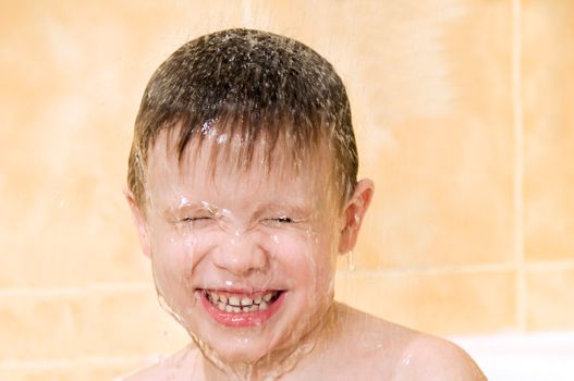 A smiling child washing in the shower 