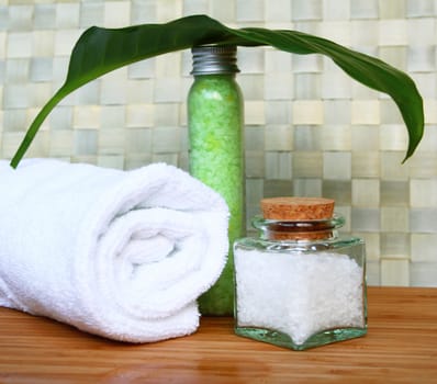 White bath towel, bottles of sea salt in spa composition

