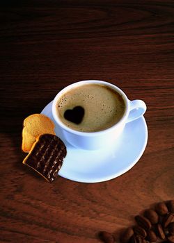 A "have a break" Illustration with a white cup of coffee - the coffee with a heart, 2 pieces of 
chocolate zwieback/rusk and a few coffee beans on a wooden background.