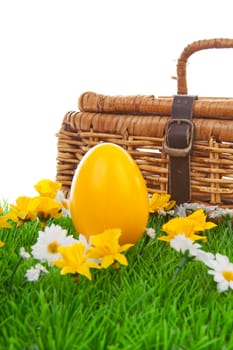 Yellow easter egg and basket on green grass