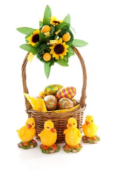 Basket with easter eggs and chickens over white background