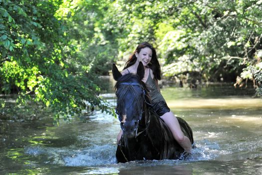 beautiful black horse in the sea and beautiful woman