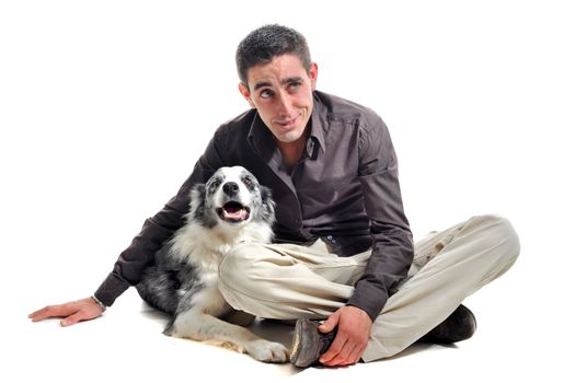 portrait of purebred border collie and smiling young man in front of white background