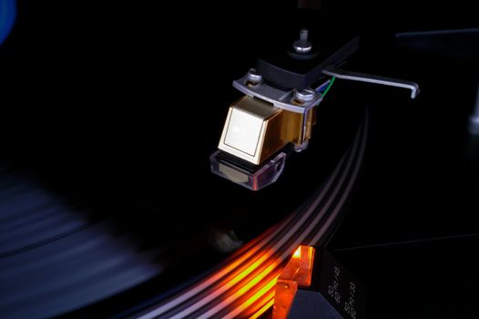 Turntable closeup showing vinyl disk pickup cartridge and strobo light