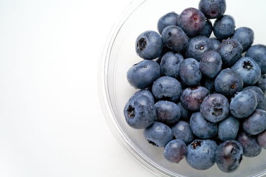 Blueberries inglass bowl from above with space for text