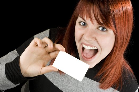 Cute smiling redhead girl holding a blank business or visiting card.