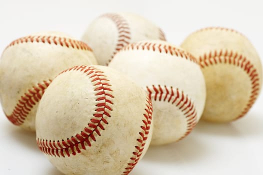a macro of several baseballs on white