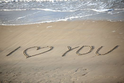 Words about love written on wet sand