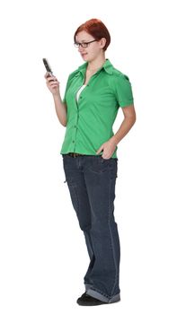 Smiling redheaded girl using a mobile phone while is standing up.