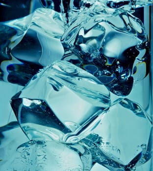 A background of bubbles forming in blue water after ice cubes