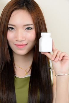 portrait of beautiful  smiling healthy asian woman is holding supplementary food container