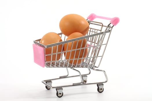Fresh eggs in shopping cart over white