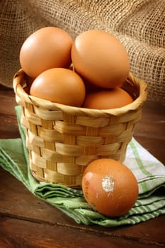 Fresh eggs in basket on wooden table