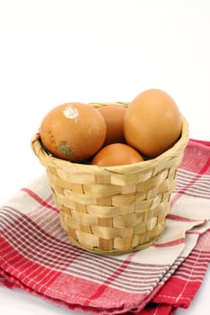 Fresh eggs in basket over white