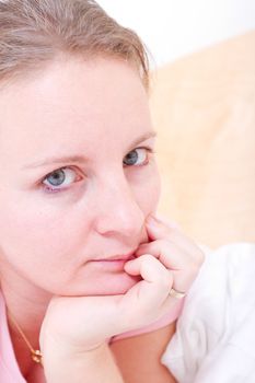 Young female woman resting on her hand and looking at camera.