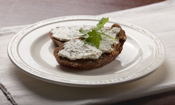 Sandwich with cottage cheese and parsley on yhe white plate