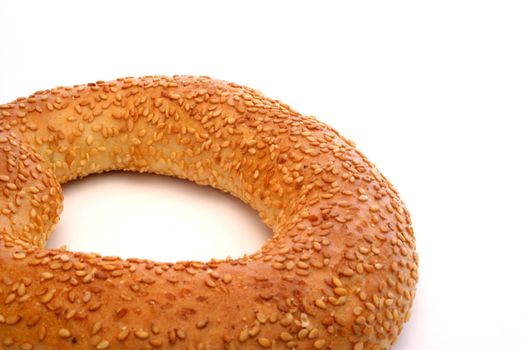 A sesame bagel lying isolated on white background.