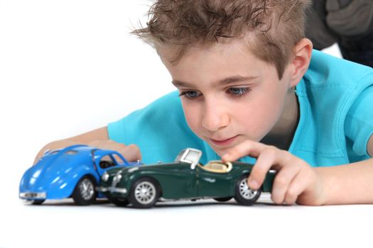 little boy playing with cars