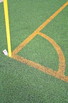 A corner of a soccer ground with yellow lines.