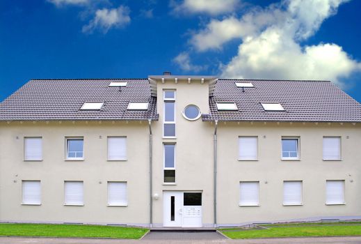 A typical apartment building with light cloudy sky.