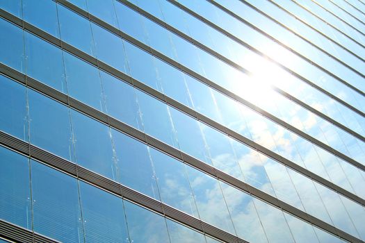 A glass storefront reflecting a bright blue sky.