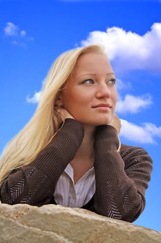 A portrait of a young beautiful blonde woman infront of a bright blue sky.
** Note: Slight blurriness, best at smaller sizes.