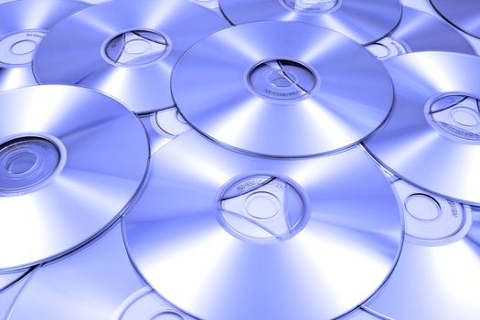 Multiple CDs randomly scattered with blue tint. Horizontal format.