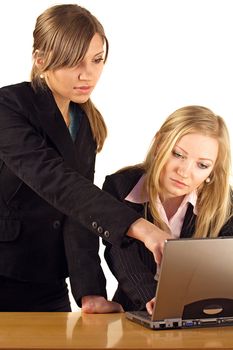 Two aspiring businesswomen working on a notebook computer. All isolated on white background.
