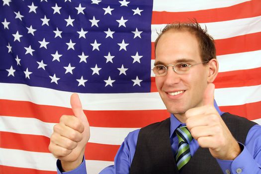 A young businessman jubilation in front of the flag of the United States of America.