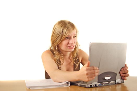 A stressed student in front of her notebook computer. All isolated on white background.