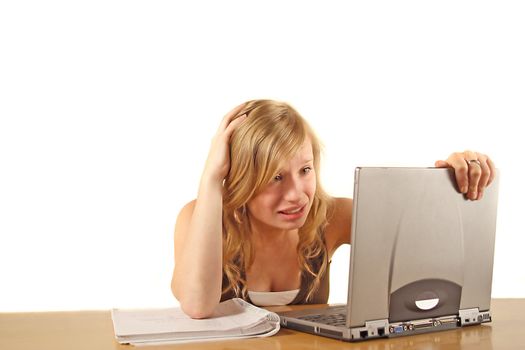 A stressed student in front of her notebook computer. All isolated on white background.