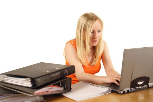 A young ambitious woman in front of her notebook computer. All isolated on white background.