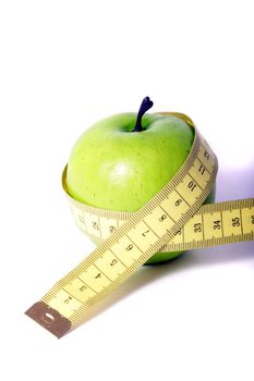 A metaphorical image showing an apple measured with a tape showing healthy diet on a white background.
