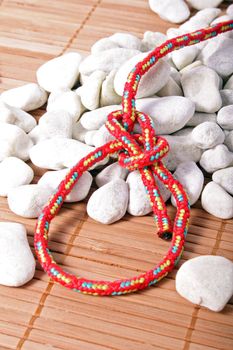A fine knotted bowline knot lying on a pile of rocks.