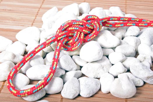 A fine knotted figure of eight loop lying on a pile of stones.