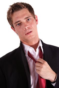 An exhausted businessman unfastening his tie. All isolated on white background.