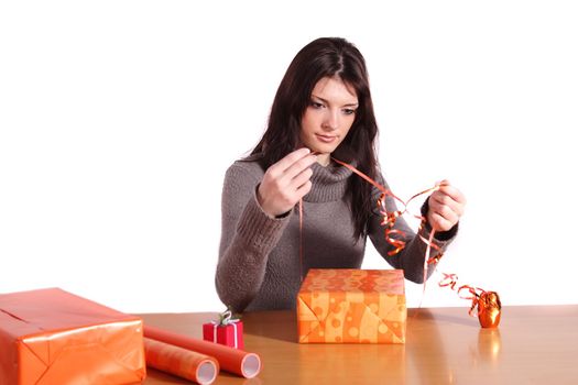 A handsome young woman wrapping presents. All isolated on white background.