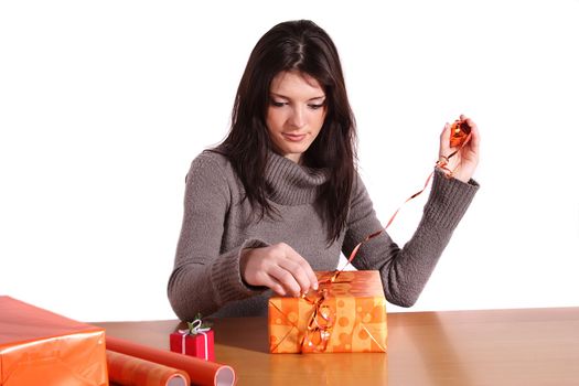 A handsome young woman wrapping presents. All isolated on white background.