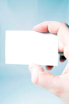 A hand holding a blank business card.