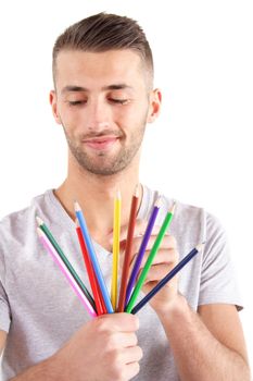 A handsome man chooses a colored crayon. All isolated on white background.